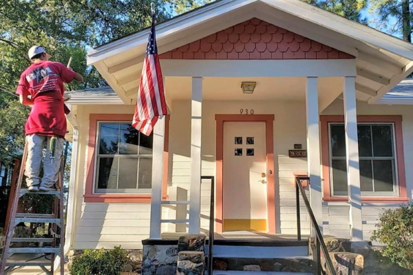 A house with an american flag on the front porch.