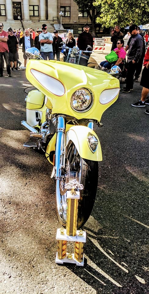 A yellow motorcycle parked on the side of a road.
